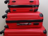 trois valises rouges empilées les unes sur les autres par terre