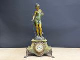 une statue de femme tenant une horloge sur une table