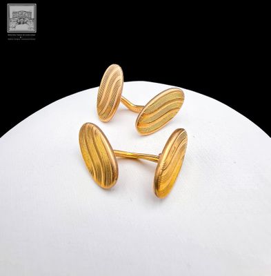trois paires de boutons de manchette plaqués or, présentées sur une assiette blanche