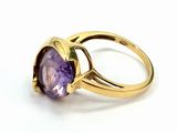 a close up of a gold ring with a purple stone