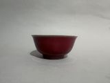 a small red bowl sitting on a white surface