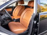 the interior of a black car with tan leather seats is shown