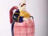 une figurine d'un homme assis sur un tonneau