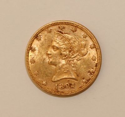 a close up of a gold coin on a white surface