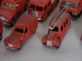 a lot of red toy cars that are on a table