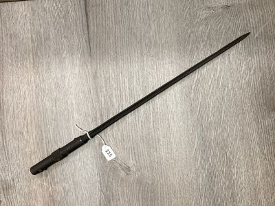 un gros plan sur un bâton noir posé sur un parquet