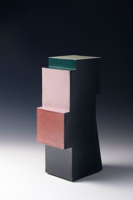 une image représentant une sculpture noire et rose posée sur une surface blanche
