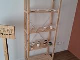 a wooden shelf with cups on it in the corner of a room