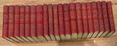 plusieurs livres rouges empilés les uns sur les autres sur une table en bois
