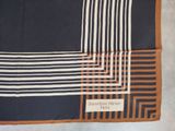 an image of a black and white and orange square scarf