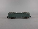 an image of a green train car sitting on top of a gray surface