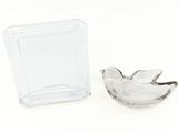 a small glass bird sitting next to a small glass box