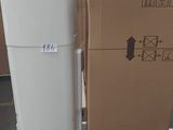 un réfrigérateur blanc posé à côté d'un carton posé par terre