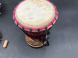a small drum and a pair of ear buds on a table