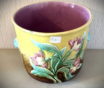 un vase jaune orné de fleurs, posé sur une table