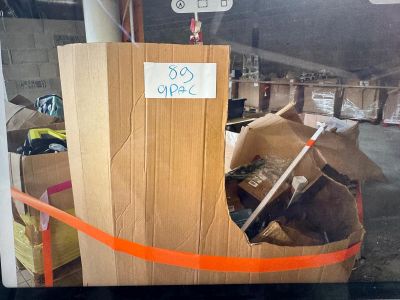 une boîte en carton sur laquelle est collé un autocollant, posée dans un entrepôt