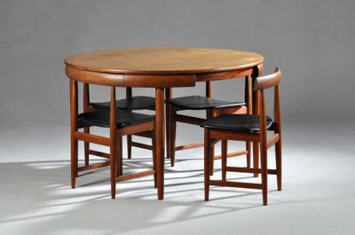 une table entourée de quatre chaises, posée sur un sol blanc