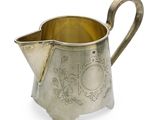 un pichet ancien plaqué argent muni d'une anse, sur fond blanc
