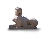 a statue of a lion sitting on a white surface