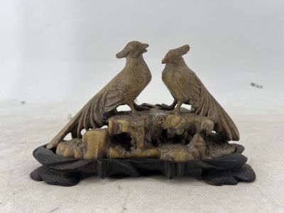 pair of pheasants sitting on a rock in the snow