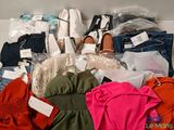 Plusieurs paires de chaussures, des vêtements et d'autres objets se trouvent dans une boîte