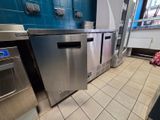 a stainless steel refrigerator in the middle of a kitchen