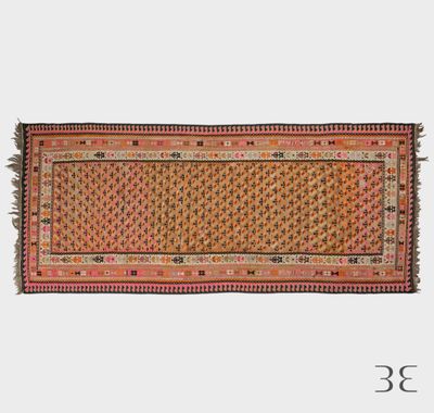 un tapis orange et rose à franges sur fond blanc