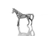 une figurine de cheval en argent posée sur une surface réfléchissante