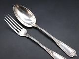 two spoons and a fork on a black surface