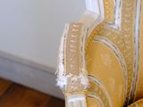 a chair that has a yellow and white striped upholstered