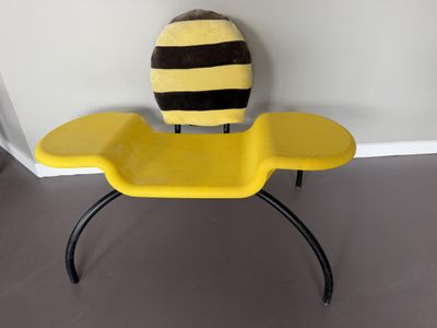 a yellow chair with a black and yellow bee on it