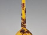 a yellow and brown vase with a flower design on it