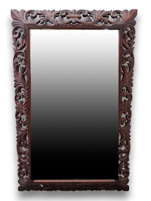 a large mirror with a wooden frame and a carved design