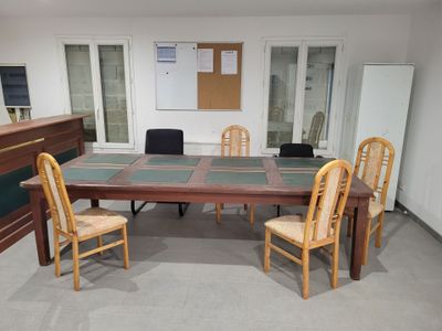 a table and chairs in a room with a whiteboard on the wall