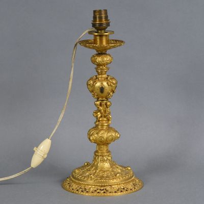 une lampe de table ancienne en laiton, avec un cordon d'alimentation branché dessus