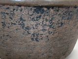 a brown bowl that is sitting on a white surface
