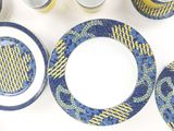 a blue and yellow dinner set on a white table