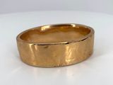 a close up of a gold ring on a white surface