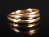 gros plan d'une bague en or sur une surface noire