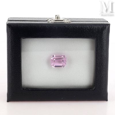 a pink tourmaline gems in a black box on a white surface
