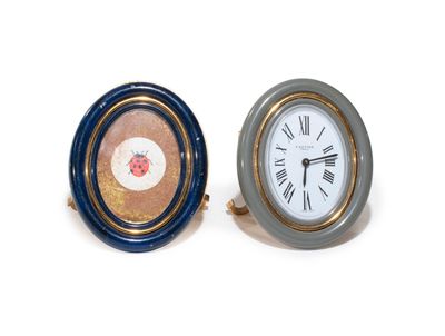 two clocks sitting next to each other on a white surface