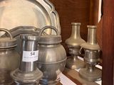a lot of silver vases and plates on a shelf