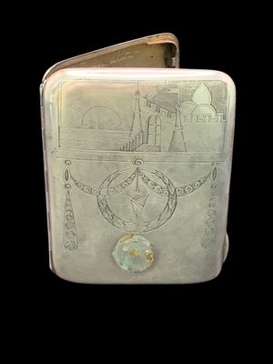 a silver cigarette case with a drawing on it