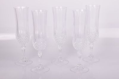 quatre verres à vin transparents posés sur une table blanche