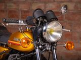 a yellow motorcycle parked in front of a brick wall
