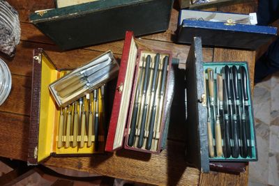 a lot of pens and pencils in a box on a table