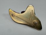 a gold metal object on a gray surface