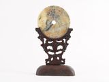 a stone object on a wooden stand on a white background
