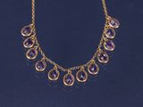 un collier en or orné d'améthystes sur fond noir