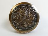 a metal button with a picture of a woman on it
